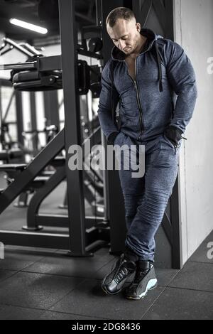 Uomo muscolare in posa nella palestra Foto Stock