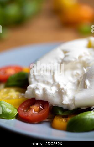 Burrata su insalata colorata di pomodoro e basilico Foto Stock