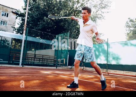 Fit Man gioca a tennis su campo Foto Stock