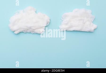 Cumulus nuvole di lana di cotone su superficie blu, layout per idee, spazio per il testo Foto Stock