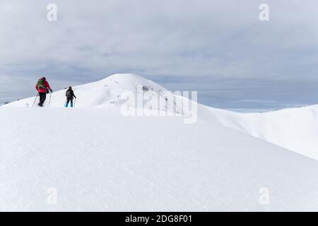 La coppia più anziana è un'escursione con racchette da neve in montagna alpina invernale. Allgau, Baviera, Germania. Foto Stock