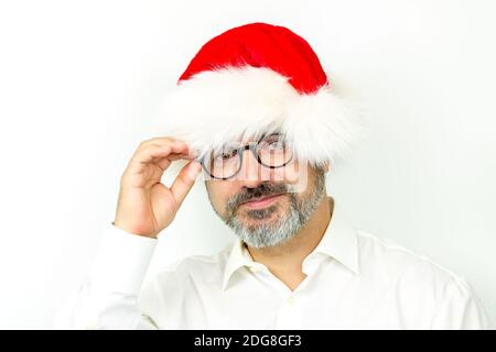 Bell'uomo anziano con bearded che indossa il cappello di Natale e gli occhiali, ritratto su sfondo bianco Foto Stock