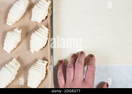 Mani donne che lavorano con pasta sfoglia e preparare croissant, primo piano. Foto Stock