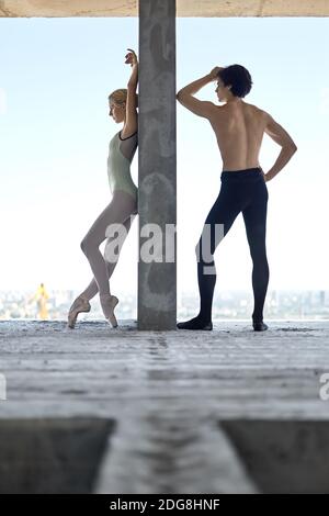 Ballerini che pongono a edificio incompiuto Foto Stock