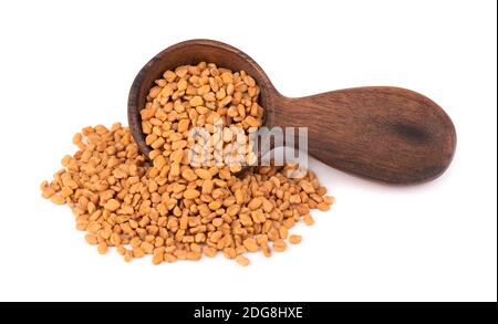 Semi di fenugreek in cucchiaio di legno, isolati su sfondo bianco. Shambala, semi di helba. Foto Stock
