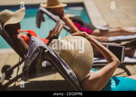 Le donne anziane si prendono il sole a bordo piscina estiva Foto Stock