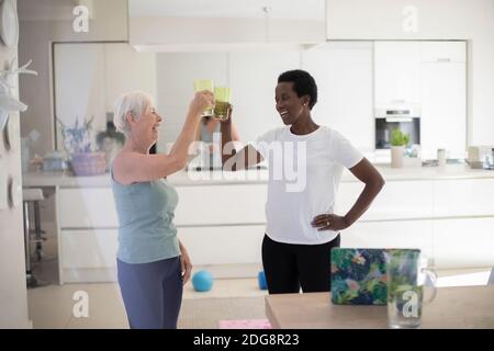 Felice donne anziane amici bere acqua dopo l'allenamento a casa Foto Stock