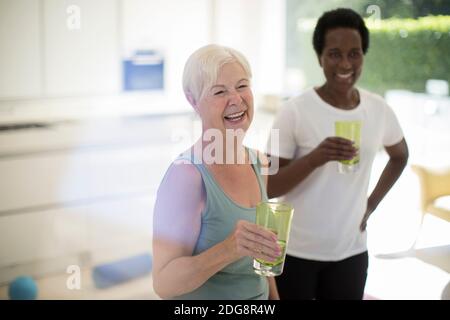 Felice donne anziane amici bere acqua dopo l'allenamento a casa Foto Stock