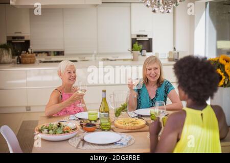 Le donne anziane si divertano con il vino bianco con il pranzo a cena tabella Foto Stock