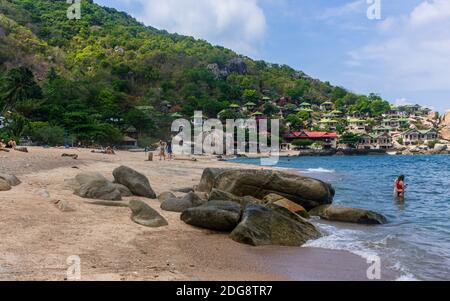 Koh Tao, Thailandia: Aprile 23 2019: isola bianca sabbia rocciosa spiaggia vista paesaggio. Onde cristalline, tempo estivo rilassante. spiaggia dell'isola hous Foto Stock