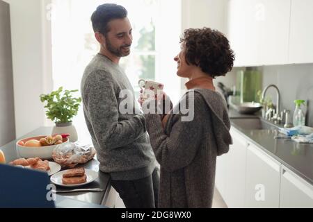 Felice coppia che parla in cucina mattina Foto Stock