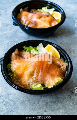 Insalata Gravlax di salmone da portare via in contenitore di plastica nera e pacchetto salsa di senape. Pronto a mangiare cibo biologico sano. Foto Stock