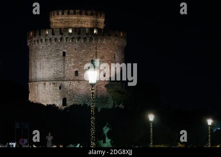 Salonicco Grecia vista notturna della Torre Bianca con decorazioni natalizie intorno. Il punto di riferimento della città con le sue rate stagionali illuminate sotto il cielo scuro. Foto Stock