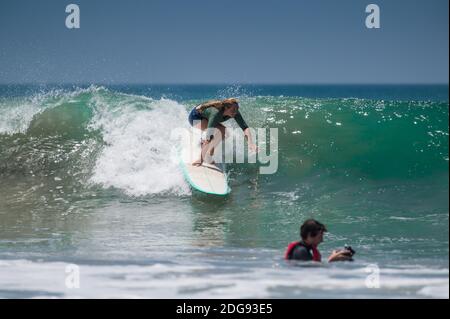 VARKALA, INDIA - Mar 14, 2020: Un fotografo maschile cercando di catturare il Surfer in azione Foto Stock