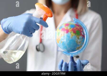 Il medico sta tenendo globo e disinfettante closeup Foto Stock