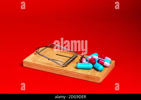 Pillole mediche, farmaci sono in un mousetrap di legno. Assistenza sanitaria, assicurazione sulla vita. Foto Stock