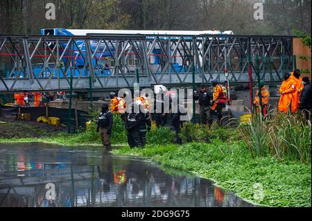 Denham, Buckinghamshire, Regno Unito. 8 dicembre 2020. Una polizia enorme e HS2 operazione è in corso per cercare di rimuovere Veteran eco attivista Dan Hooper noto come swampy che è attualmente bloccato su una struttura di bambù alta 30 piedi nel fiume Colne nel Denham Country Park. Gli HS2 stanno costruendo un ponte temporaneo sul fiume e gli attivisti anti della ribellione anti HS2 stanno cercando di fermare il ponte in costruzione e altri alberi in via di distruzione da parte dell'HS2 per il controverso collegamento ferroviario ad alta velocità. Credit: Maureen McLean/Alamy Live News Foto Stock