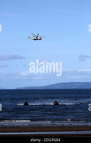 Scottish International Airshow Sabato 5 Settembre, Ayr, Ayrshire, Scozia, Regno Unito. Royal Marines sostenuto da un elicottero e la miniera spazzatrice fase di un esercizio di ostaggi gratuiti sulla spiaggia, con armi da fuoco e personale militare.Scottish Air Show prova di Royal Marine Assault a Ayr Beach con 43 Commando Fleet Protection un elicottero Merlin e Scozzese e Irlanda del Nord Yeomanry Foto Stock