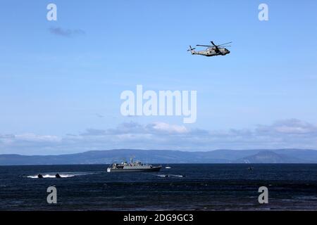 Scottish International Airshow Sabato 5 Settembre, Ayr, Ayrshire, Scozia, Regno Unito. Royal Marines sostenuto da un elicottero e la miniera spazzatrice fase di un esercizio di ostaggi gratuiti sulla spiaggia, con armi da fuoco e personale militare.Scottish Air Show prova di Royal Marine Assault a Ayr Beach con 43 Commando Fleet Protection un elicottero Merlin e Scozzese e Irlanda del Nord Yeomanry Foto Stock