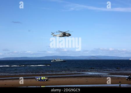 Scottish International Airshow Sabato 5 Settembre, Ayr, Ayrshire, Scozia, Regno Unito. Royal Marines sostenuto da un elicottero e la miniera spazzatrice fase di un esercizio di ostaggi gratuiti sulla spiaggia, con armi da fuoco e personale militare.Scottish Air Show prova di Royal Marine Assault a Ayr Beach con 43 Commando Fleet Protection un elicottero Merlin e Scozzese e Irlanda del Nord Yeomanry Foto Stock