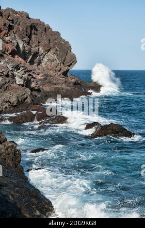 Onde increspate che colpiscono la costa orientale vulcanica dell'isola al Montana de la Mar, vedute dell'Atlantico e della vicina spiaggia di Puertito de Guimar Foto Stock