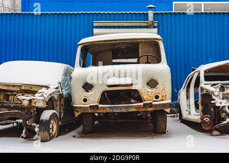 Le vecchie auto arrugginite rotte su una scaravata sotto la neve Foto Stock