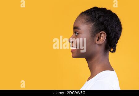Profilo Ritratto di African American Woman in posa su sfondo giallo Foto Stock