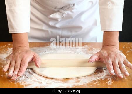 come fare udon giapponesi tagliatelle; usare un tondino per arrotolare l'impasto Foto Stock