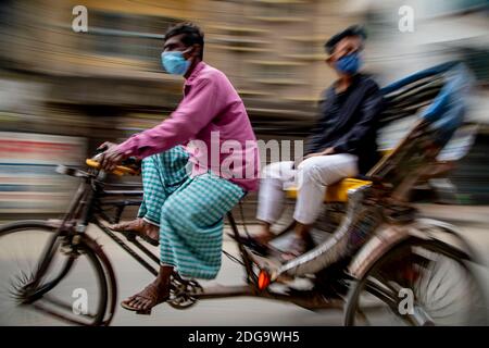 Pulitori di risciò per le strade di Puran Dhaka - Old Dhaka in Bangladesh. I risciò sono tricicli alimentati a pedale, ma usati per essere tirati a mano, da qui 'estrattore di risciò'. Oggi molti dei risciò sono persino convertiti per essere alimentati da un motore elettrico. Foto Stock