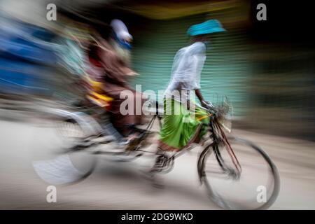 Pulitori di risciò per le strade di Puran Dhaka - Old Dhaka in Bangladesh. I risciò sono tricicli alimentati a pedale, ma usati per essere tirati a mano, da qui 'estrattore di risciò'. Oggi molti dei risciò sono persino convertiti per essere alimentati da un motore elettrico. Foto Stock