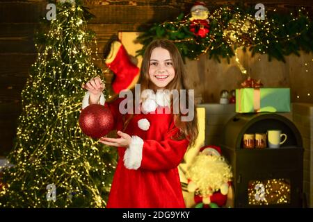 Servizi di noleggio decorazioni. Felice infanzia. Bambina festeggia il natale. Noleggio accessori per le vacanze. Concetto di vacanza invernale. Festeggia il nuovo anno vicino all'albero di natale. Noleggio di costumi per il carnevale. Foto Stock