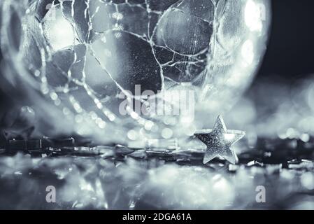 Foto macro di vetro rotto sfera silver star con luce bokeh di fondo Foto Stock