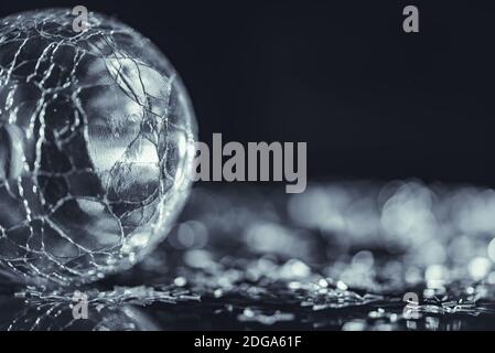 Foto macro di vetro rotto sfera silver star con luce bokeh di fondo Foto Stock