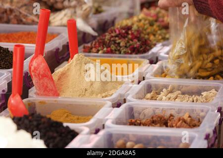 Varie spezie orientali in scatole di plastica. Foto Stock