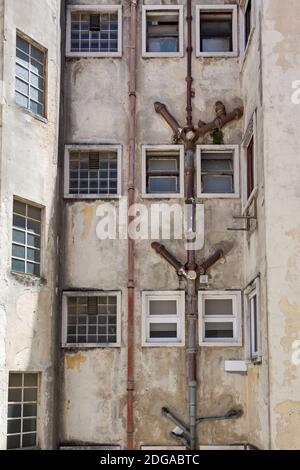 Tubi di drenaggio esterni esposti della vecchia casa di appartamenti a Lisbona, Portogallo Foto Stock