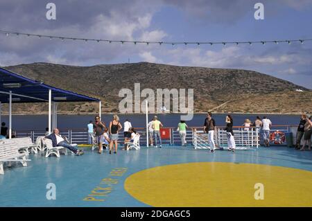 Passeggeri e area eliporto sul ponte aperto di un traghetto di fronte all'isola di LIPSI, Dodecanese, Grecia Foto Stock