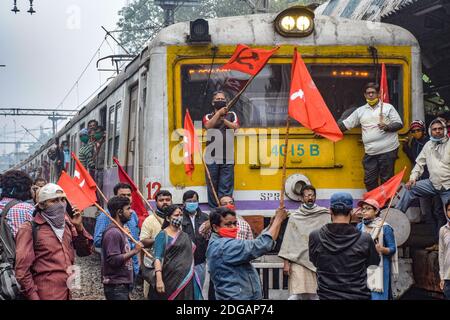 Kolkata, India. 8 dicembre 2020. I sostenitori del partito comunista hanno bandiere mentre bloccano la via ferroviaria durante la dimostrazione. Lo sciopero All India chiamato dai sindacati dei contadini contro le nuove leggi sull'agricoltura è sostenuto dai partiti di opposizione. Credit: SOPA Images Limited/Alamy Live News Foto Stock