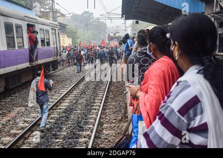 Kolkata, India. 8 dicembre 2020. I sostenitori del partito comunista hanno bandiere mentre bloccano la via ferroviaria durante la dimostrazione. Lo sciopero All India chiamato dai sindacati dei contadini contro le nuove leggi sull'agricoltura è sostenuto dai partiti di opposizione. Credit: SOPA Images Limited/Alamy Live News Foto Stock