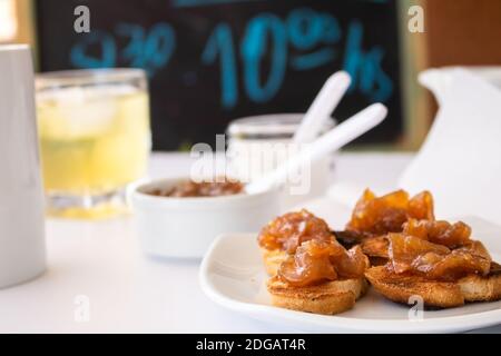 Pane tostato fatto in casa con un delizioso chutney fatto in casa di mele e cipolle, con cannella su una tavola bianca chiara. Marmellata perfetta per la colazione. Colazione Foto Stock