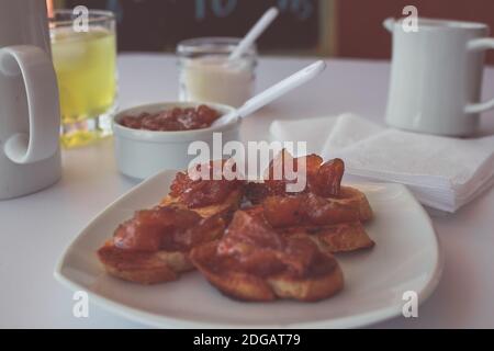 Pane tostato fatto in casa con un delizioso chutney fatto in casa di mele e cipolle, con cannella su una tavola bianca chiara. Marmellata perfetta per la colazione. Colazione Foto Stock