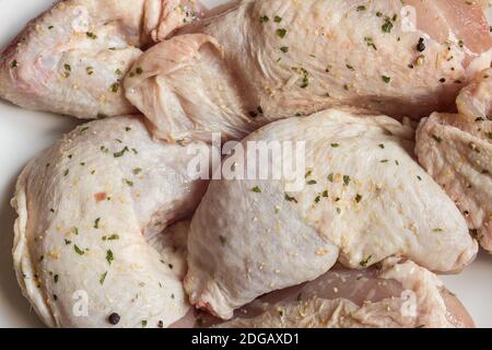 Primo piano di pollo disossato crudo condito con sale e spezie pronte per la cottura alla griglia. Cibo e carne. Fondo di tessitura organico. Foto Stock