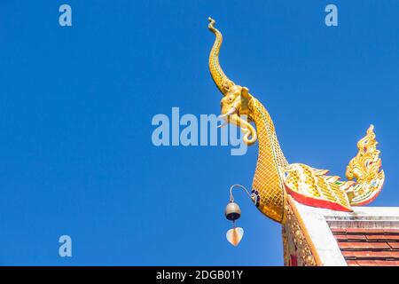 Belle sculture dorate di naga sul tetto della chiesa sotto lo sfondo blu del cielo a Wat Phra che Doi Tung, uno dei quali si ritiene contenere l Foto Stock