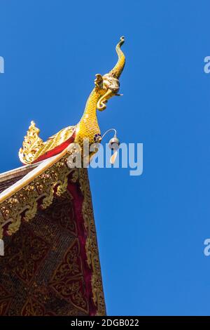 Belle sculture dorate di naga sul tetto della chiesa sotto lo sfondo blu del cielo a Wat Phra che Doi Tung, uno dei quali si ritiene contenere l Foto Stock