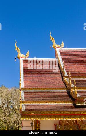 Belle sculture dorate di naga sul tetto della chiesa sotto lo sfondo blu del cielo a Wat Phra che Doi Tung, uno dei quali si ritiene contenere l Foto Stock