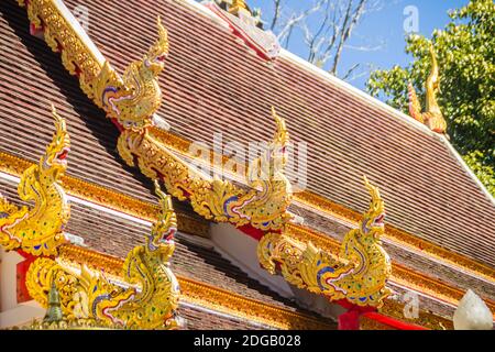Belle sculture dorate di naga sul tetto della chiesa sotto lo sfondo blu del cielo a Wat Phra che Doi Tung, uno dei quali si ritiene contenere l Foto Stock