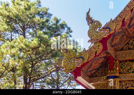 Belle sculture dorate di naga sul tetto della chiesa sotto lo sfondo blu del cielo a Wat Phra che Doi Tung, uno dei quali si ritiene contenere l Foto Stock