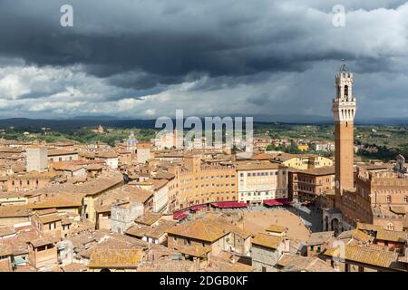 Vista panoramica sulla città che mostra Torre del Mangia e Piazza del campo sotto le nuvole buie della tempesta, come si vede da Facciatone, Siena, Toscana, Italia Foto Stock