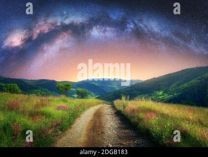 Arco Via Lattea sulla strada sterrata di montagna in estate di notte Foto Stock