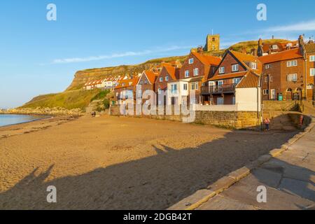 Vista della chiesa di St Mary, le case del porto e la spiaggia al tramonto, Whitby, Yorkshire, Inghilterra, Regno Unito, Europa Foto Stock