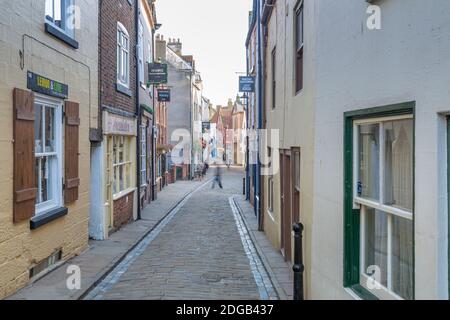 Vista dei negozi sulla tradizionale strada acciottolata nel centro storico della città, Whitby, Yorkshire, Inghilterra, Regno Unito, Europa Foto Stock